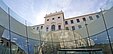 Im Vordergrund ist ein gläserner Trichter des Joanneumsviertels, im Hintergrund die Fassade der Neuen Galerie zu sehen.